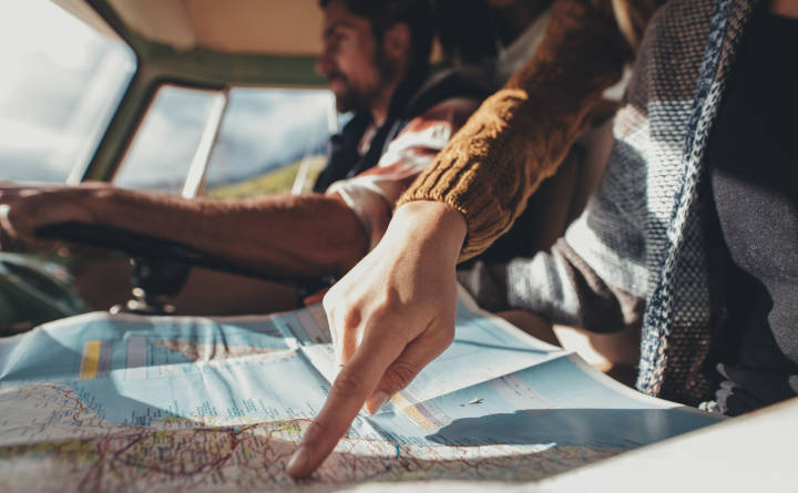 Friends on road trip using map for directions