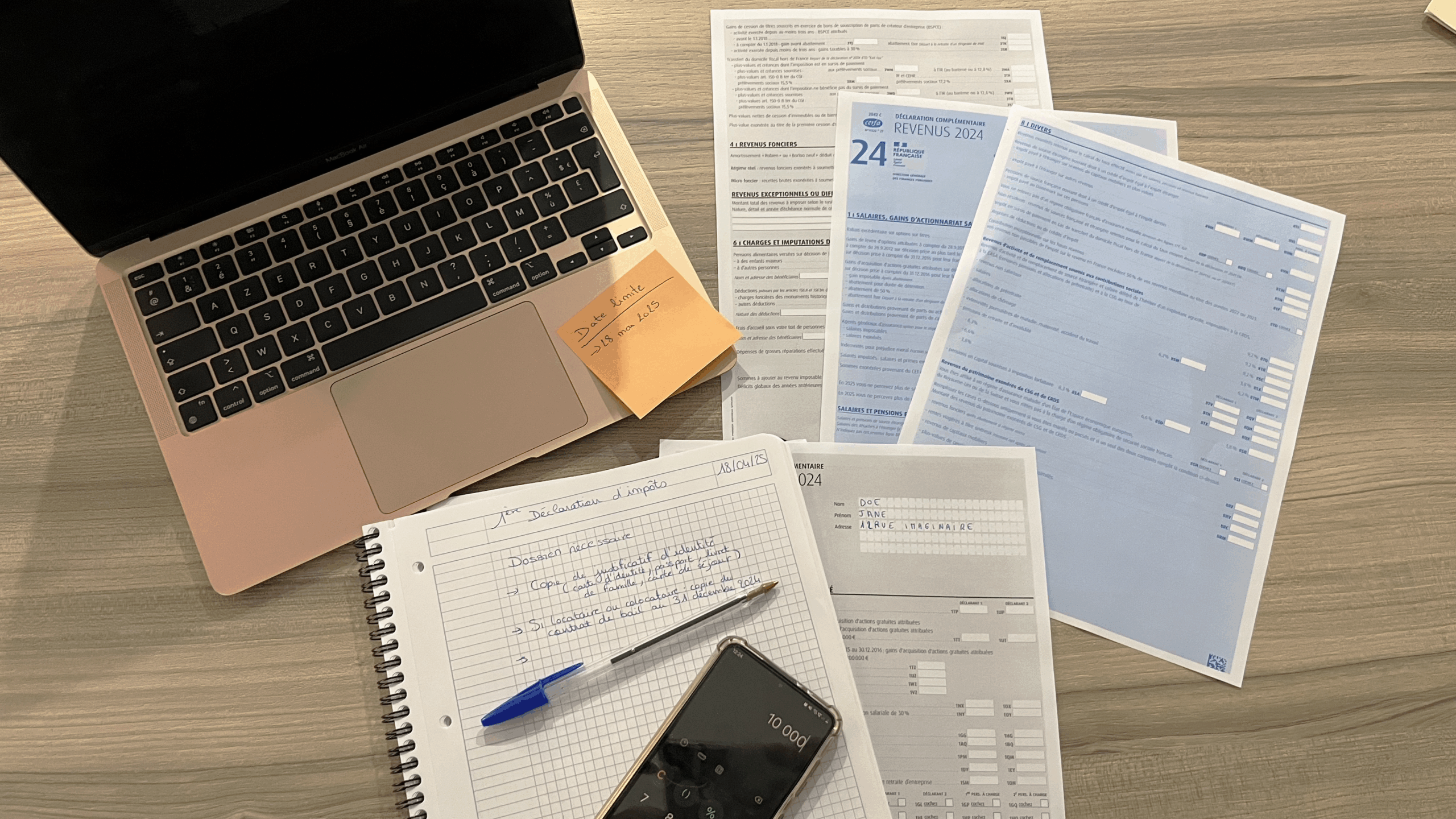 Bureau vu du dessus avec papier d'impôts, ordinateur et calculatrice